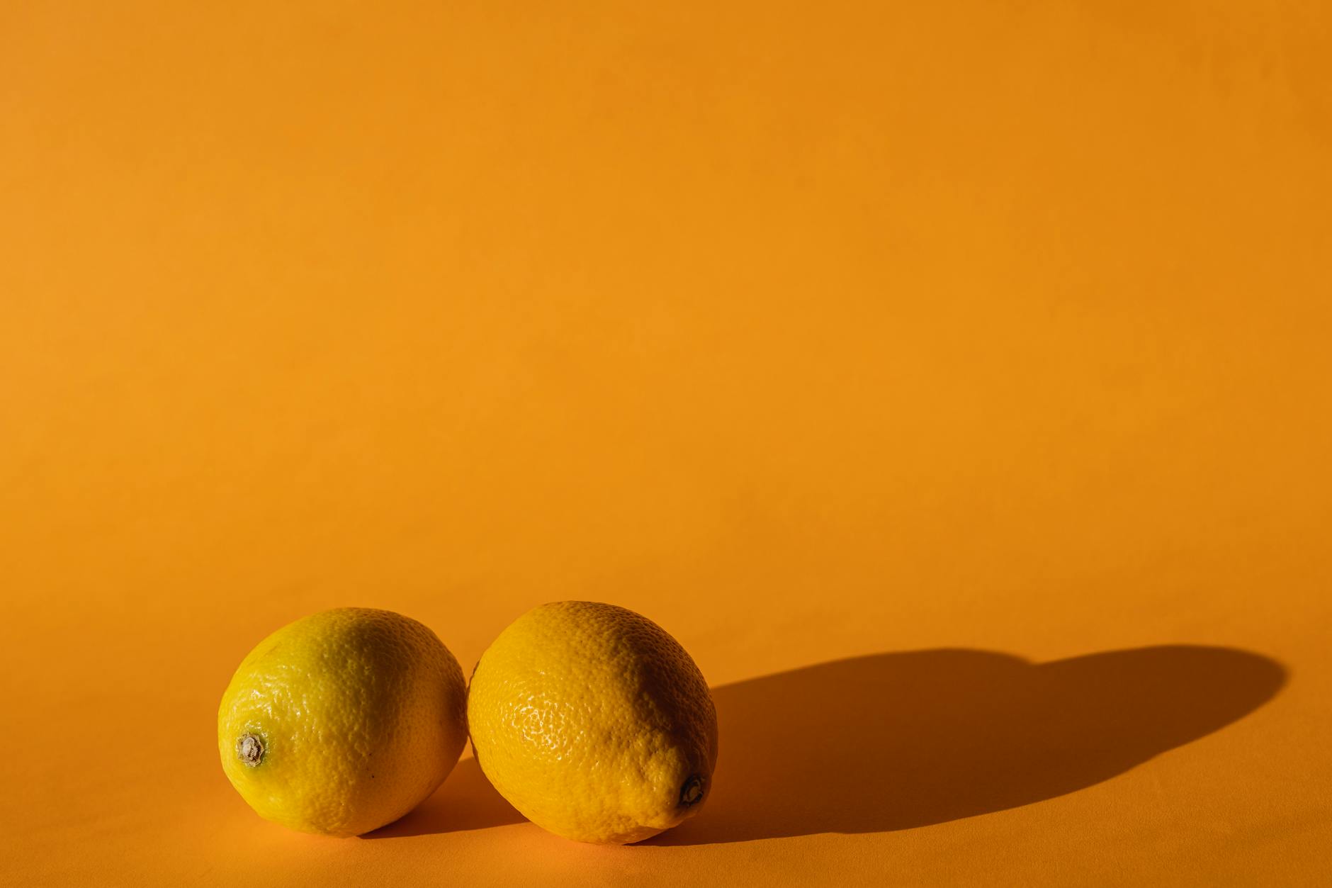 Ripe vivid lemons on a yellow background, representing natural cycles and phases